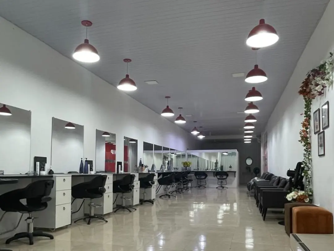 Vista do salão, com as estações de atendimento e luminárias vermelhas